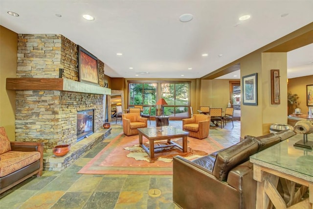 living area featuring a fireplace, stone finish floor, and recessed lighting