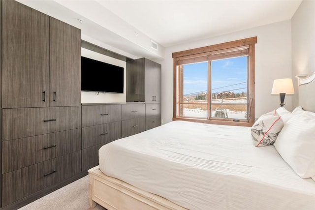 bedroom with visible vents and light carpet