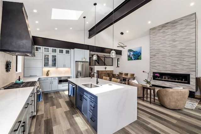 89 Wilderness Dr, Breckenridge, CO 80424 - kitchen featuring appliances with stainless steel finishes, exhaust hood, open floor plan, wood finished floors, and high vaulted ceiling