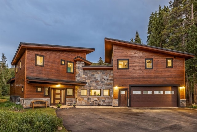 89 Wilderness Dr, Breckenridge, CO 80424 - contemporary house featuring stone siding, asphalt driveway, an attached garage, and covered porch