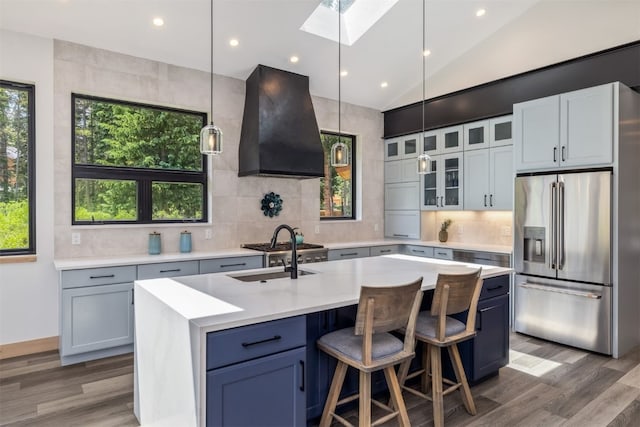 89 Wilderness Dr, Breckenridge, CO 80424 - kitchen featuring stainless steel refrigerator with ice dispenser, ventilation hood, a skylight, wood finished floors, and light countertops