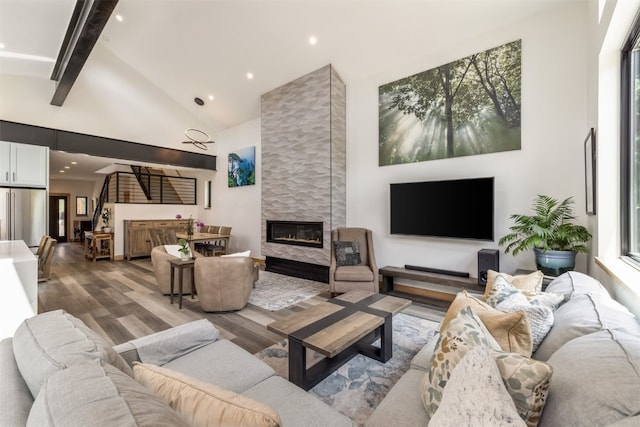 89 Wilderness Dr, Breckenridge, CO 80424 - living room with wood finished floors, a tiled fireplace, high vaulted ceiling, beamed ceiling, and recessed lighting