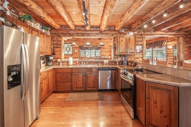 192 Johnson Rd, Silverthorne, CO 80498 - kitchen with appliances with stainless steel finishes, a sink, a peninsula, wooden ceiling with exposed beams, and log walls