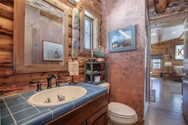 192 Johnson Rd, Silverthorne, CO 80498 - bathroom with rustic walls, vanity, toilet, and wood finished floors