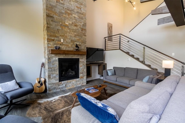 0125 Lake Ridge Cir Unit 1867, Keystone, CO 80435 - living area featuring wood finished floors, a high ceiling, stairs, and a stone fireplace