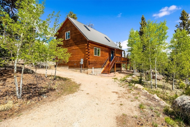 146 Atoka Dr, Como, CO 80432 - view of front facade featuring stairway, log siding, a deck, driveway, and metal roof