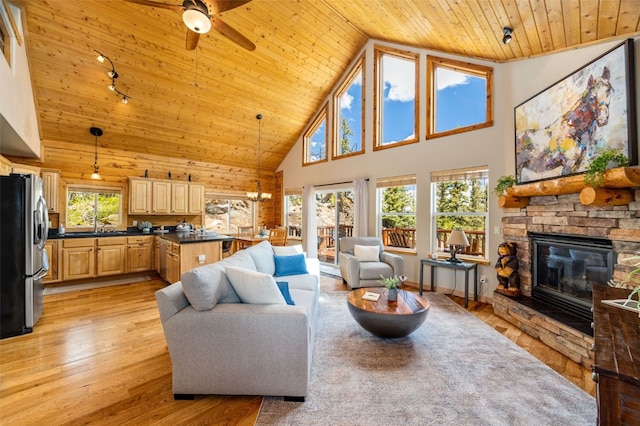 146 Atoka Dr, Como, CO 80432 - living area with wooden ceiling, high vaulted ceiling, a ceiling fan, a stone fireplace, and light wood-type flooring