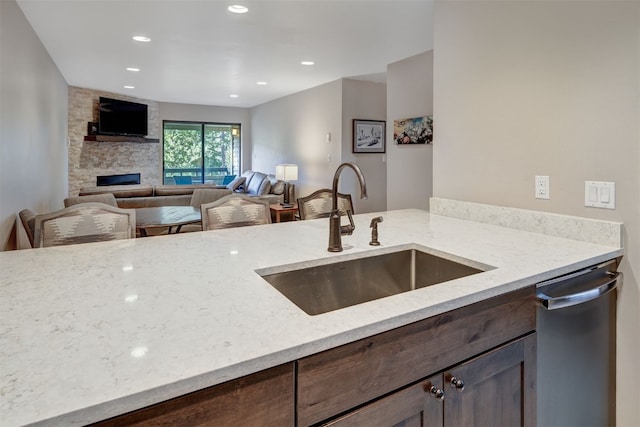 1001 Grandview Dr Unit 22, Breckenridge, CO 80424 - kitchen featuring a sink, light stone counters, a fireplace, dark brown cabinets, and recessed lighting