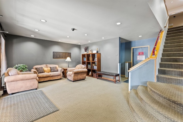 carpeted living area with recessed lighting and stairs