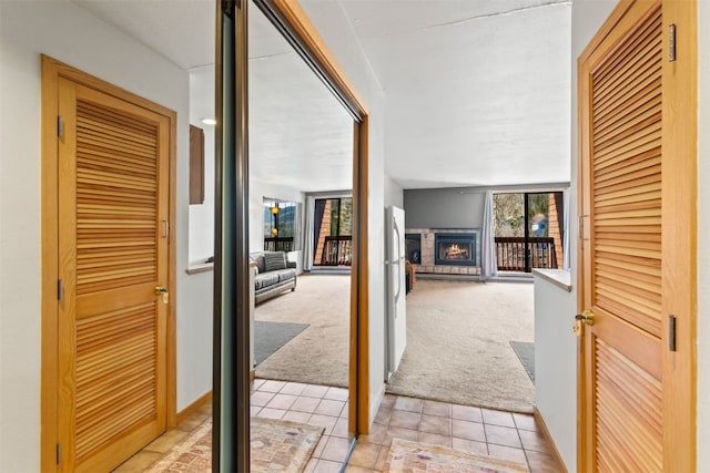 hall featuring light carpet and light tile patterned floors