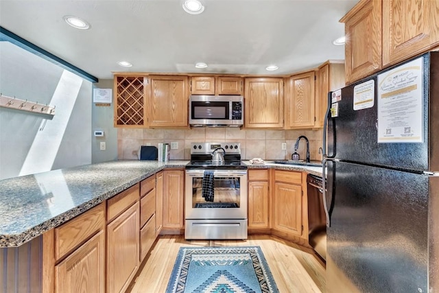 2615 Apres Ski Way Unit B1, Steamboat Springs, CO 80487 - kitchen featuring black appliances, a sink, light wood-type flooring, a peninsula, and recessed lighting