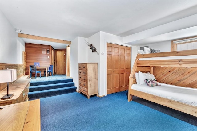 2615 Apres Ski Way Unit B1, Steamboat Springs, CO 80487 - bedroom featuring carpet flooring, wood walls, and a closet