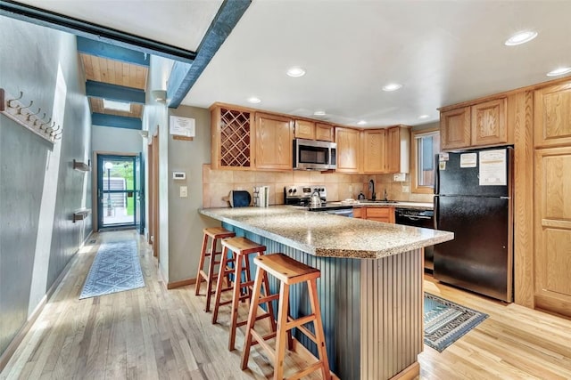 2615 Apres Ski Way Unit B1, Steamboat Springs, CO 80487 - kitchen featuring black appliances, light wood-style flooring, light countertops, a peninsula, and recessed lighting