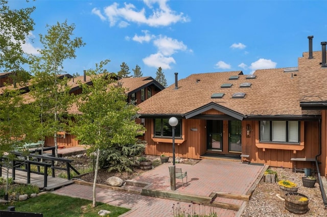 2615 Apres Ski Way Unit B1, Steamboat Springs, CO 80487 - back of property featuring roof with shingles, board and batten siding, and a patio