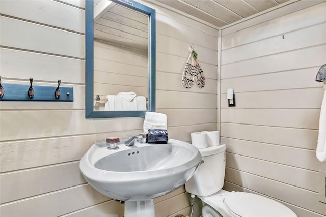 2615 Apres Ski Way Unit B1, Steamboat Springs, CO 80487 - half bathroom featuring toilet, wooden walls, wooden ceiling, and a sink