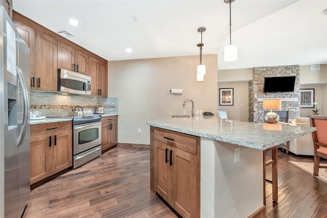 1175 Bangtail Way Unit 4107, Steamboat Springs, CO 80487 - kitchen featuring stainless steel appliances, dark wood-style floors, a breakfast bar, decorative backsplash, and open floor plan