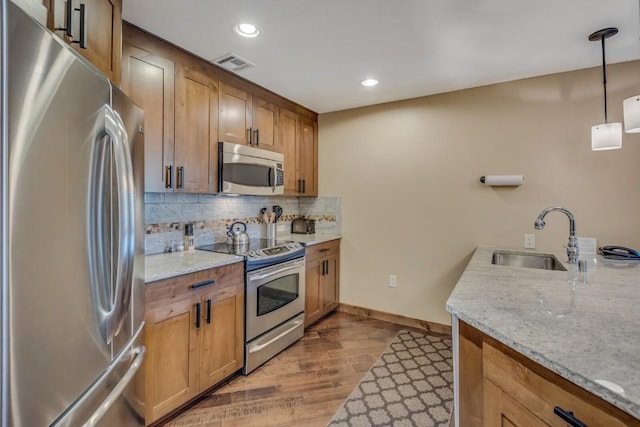 1175 Bangtail Way Unit 4107, Steamboat Springs, CO 80487 - kitchen featuring stainless steel appliances, wood finished floors, decorative backsplash, recessed lighting, and light stone countertops