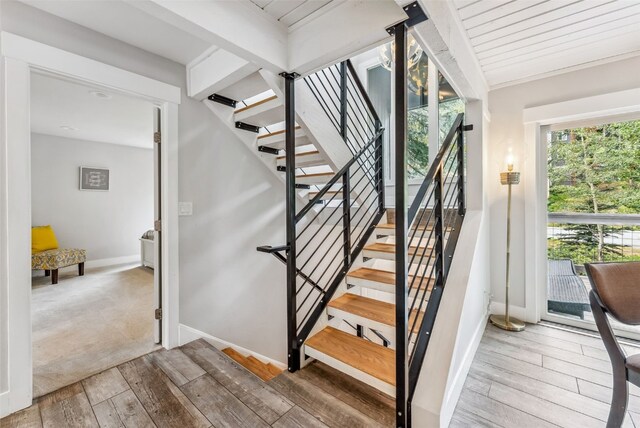 staircase with beamed ceiling, wood-type flooring, and wood ceiling