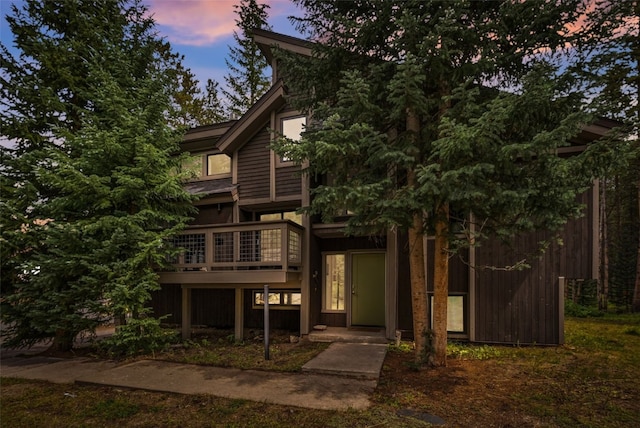 back house at dusk featuring a deck