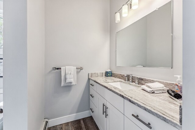 bathroom featuring hardwood / wood-style floors, vanity, and a baseboard radiator