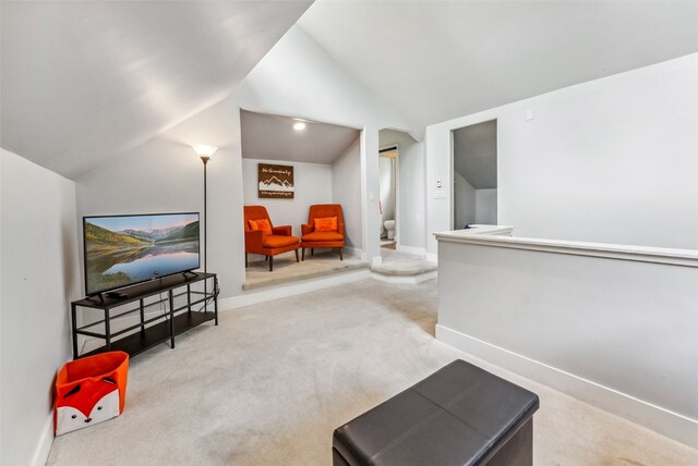 sitting room with carpet floors and vaulted ceiling