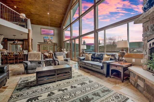 185 S Fuller Placer Rd, Breckenridge, CO 80424 - living area featuring wooden ceiling, high vaulted ceiling, stone tile flooring, plenty of natural light, and a stone fireplace
