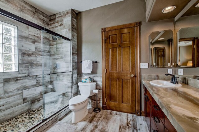 185 S Fuller Placer Rd, Breckenridge, CO 80424 - full bathroom featuring toilet, vanity, a shower stall, wood finished floors, and tile walls