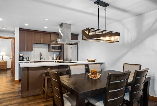 dining room featuring baseboards, recessed lighting, and dark wood finished floors