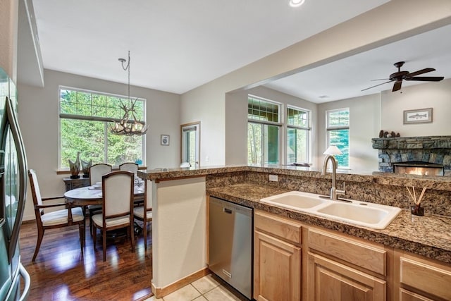 180 Robin Dr Unit 180, Silverthorne, CO 80498 - kitchen with stainless steel appliances, a sink, plenty of natural light, and a stone fireplace