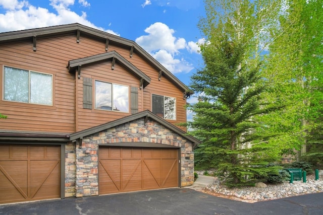 180 Robin Dr Unit 180, Silverthorne, CO 80498 - view of front of home with stone siding, an attached garage, and driveway