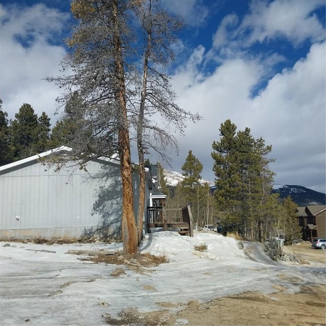 view of snow covered exterior with a wooden deck
