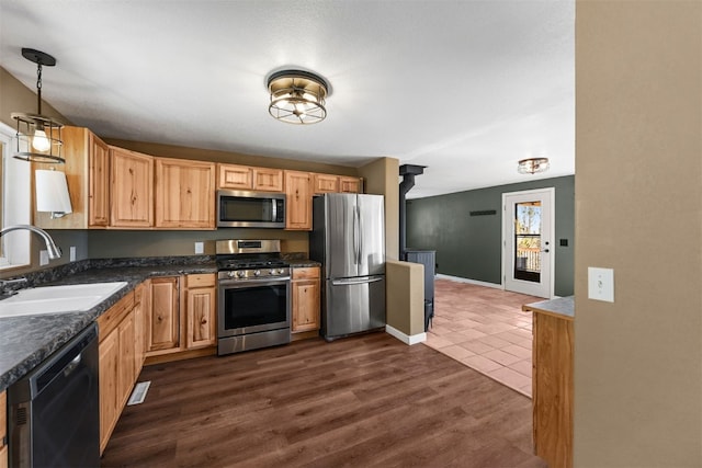 491 Valley Of The Sun Dr, Fairplay, CO 80440 - kitchen featuring appliances with stainless steel finishes, a sink, dark countertops, decorative light fixtures, and light brown cabinets