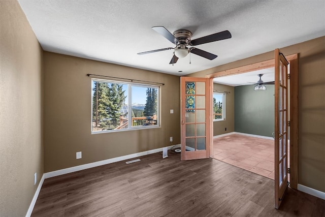 491 Valley Of The Sun Dr, Fairplay, CO 80440 - unfurnished room featuring a ceiling fan, french doors, wood finished floors, baseboards, and a textured ceiling