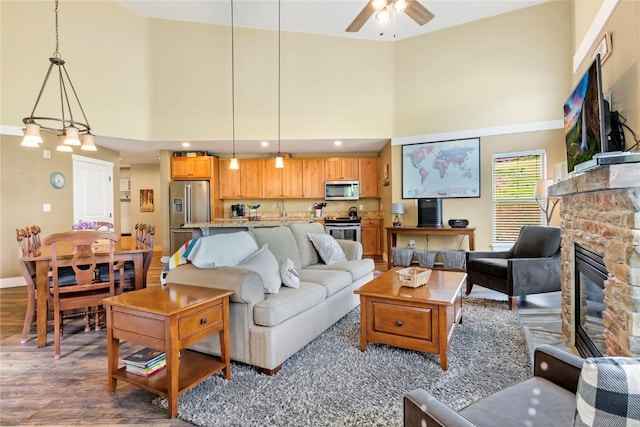 300 Base Camp Cir Unit 405, Granby, CO 80446 - living area with a high ceiling, a ceiling fan, a stone fireplace, and dark wood-style flooring