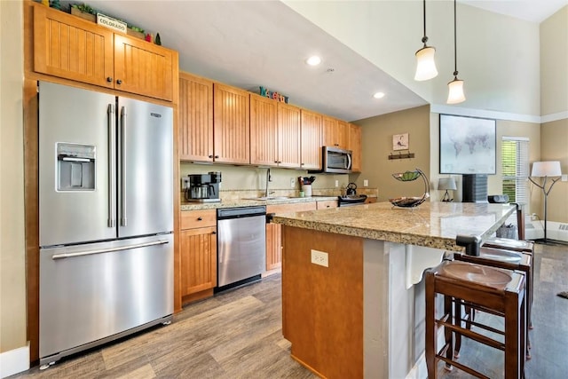 300 Base Camp Cir Unit 405, Granby, CO 80446 - kitchen with appliances with stainless steel finishes, a kitchen bar, light countertops, light wood-type flooring, and recessed lighting