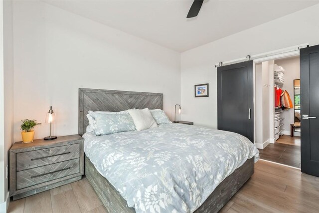 2894 Owl Hoot Trl, Steamboat Springs, CO 80487 - bedroom featuring wood finished floors, a barn door, ceiling fan, and baseboards