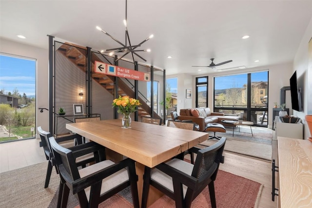 2894 Owl Hoot Trl, Steamboat Springs, CO 80487 - dining area featuring wood finished floors, stairway, recessed lighting, a ceiling fan, and a chandelier