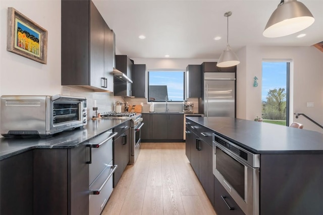 2894 Owl Hoot Trl, Steamboat Springs, CO 80487 - kitchen with built in appliances, dark countertops, modern cabinets, healthy amount of natural light, and recessed lighting