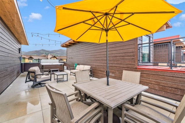 2894 Owl Hoot Trl, Steamboat Springs, CO 80487 - view of patio / terrace featuring a hot tub, outdoor dining space, and a mountain view