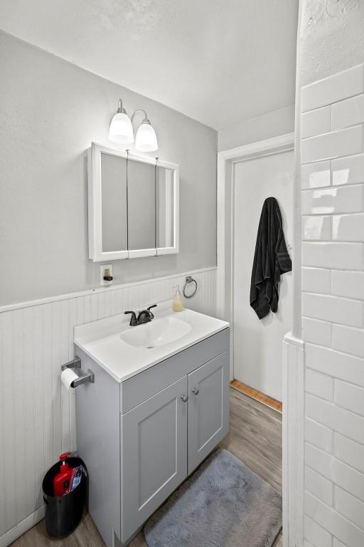 410 Washington St, Craig, CO 81625 - bathroom with wainscoting, wood finished floors, and vanity
