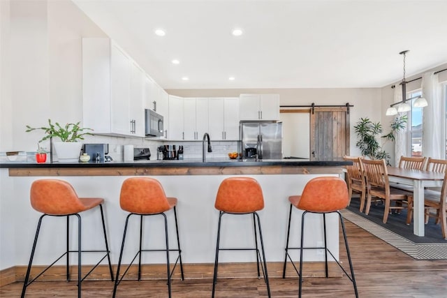 342 Lake View Rd, Hayden, CO 81639 - kitchen with dark countertops, a breakfast bar, stainless steel fridge with ice dispenser, a peninsula, and backsplash