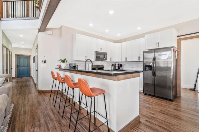 342 Lake View Rd, Hayden, CO 81639 - kitchen featuring dark countertops, appliances with stainless steel finishes, a kitchen breakfast bar, a peninsula, and baseboards