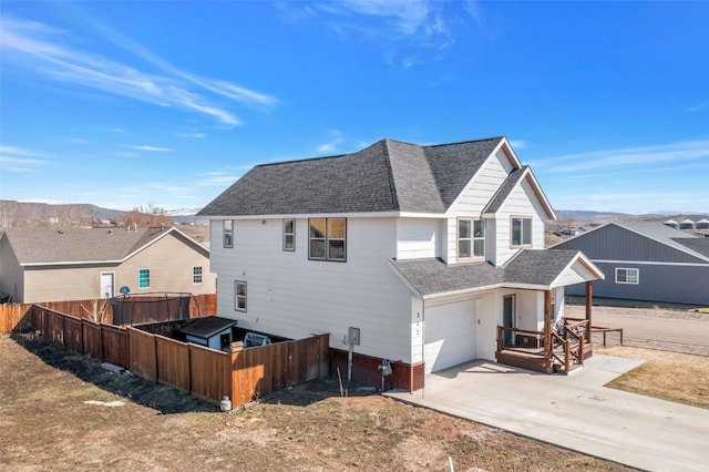 342 Lake View Rd, Hayden, CO 81639 - back of house featuring an attached garage, roof with shingles, fence, and concrete driveway