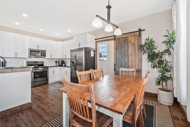 342 Lake View Rd, Hayden, CO 81639 - dining area featuring recessed lighting, baseboards, dark wood-style floors, and a barn door