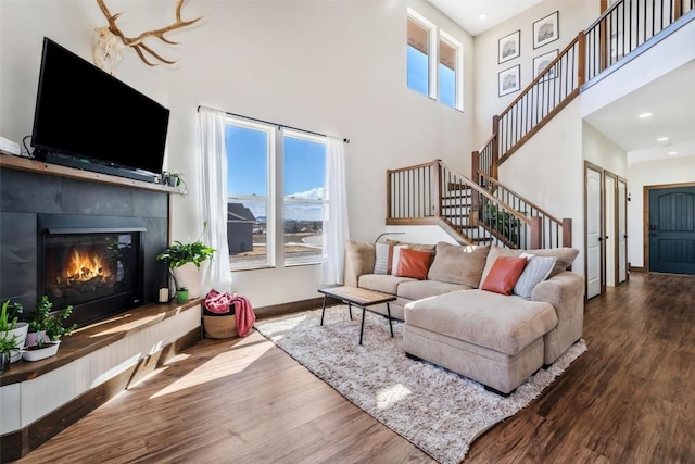 342 Lake View Rd, Hayden, CO 81639 - living area featuring stairs, wood finished floors, a high ceiling, recessed lighting, and a tiled fireplace
