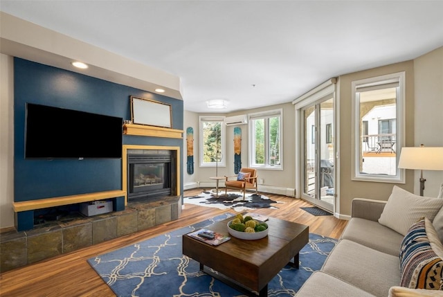 2800 Eagleridge Dr Unit C1, Steamboat Springs, CO 80487 - living room featuring a wall mounted AC, a tile fireplace, wood finished floors, and recessed lighting