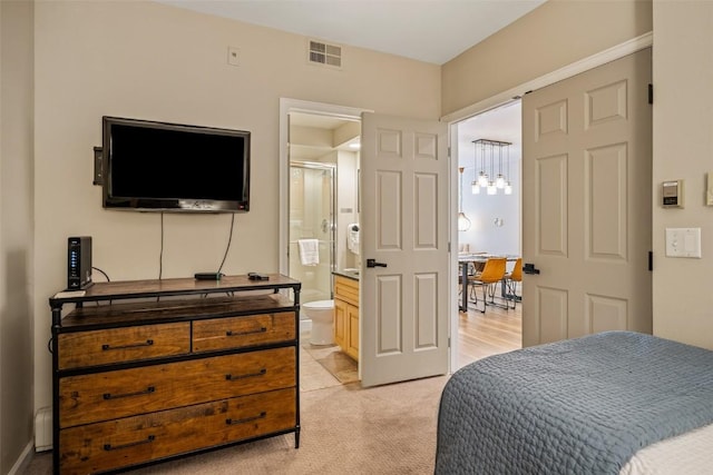 2800 Eagleridge Dr Unit C1, Steamboat Springs, CO 80487 - bedroom with light carpet, ensuite bath, and a chandelier