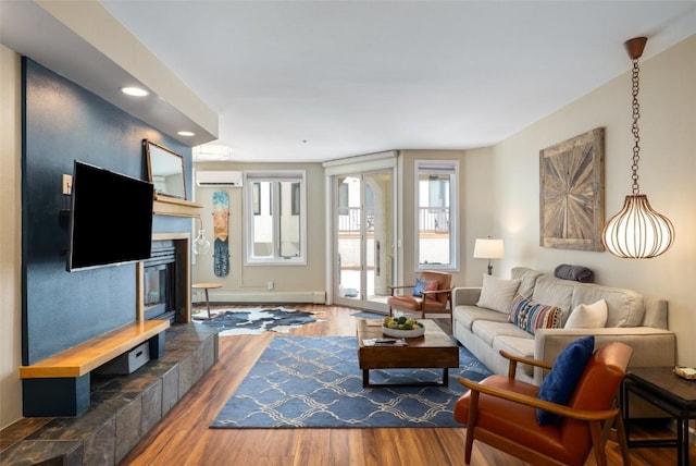 2800 Eagleridge Dr Unit C1, Steamboat Springs, CO 80487 - living area with wood finished floors, recessed lighting, an AC wall unit, a tile fireplace, and a baseboard heating unit