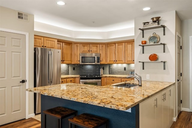 2800 Eagleridge Dr Unit C1, Steamboat Springs, CO 80487 - kitchen with stainless steel appliances, open shelves, a peninsula, a kitchen breakfast bar, and wood finished floors