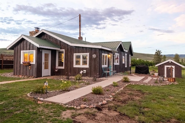 33685 State Highway 134, Toponas, CO 80479 - view of front of house with board and batten siding, a front lawn, a chimney, and a metal roof